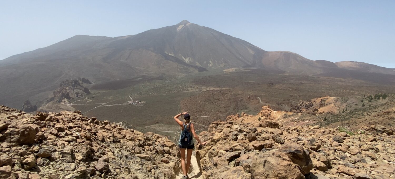 Osoba stojąca na punkcie widokowym w Parku Narodowym Teide z panoramą wulkanu Teide w tle – trudny szlak trekkingowy na Teneryfie.