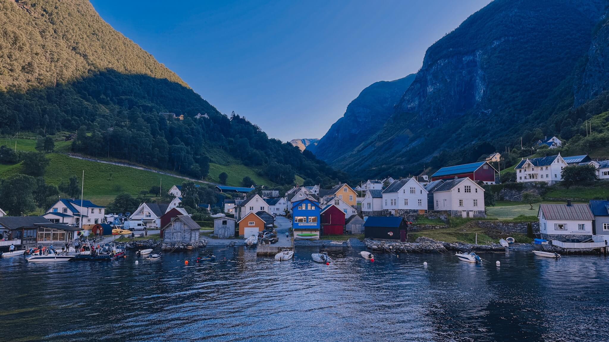 Mała norweska wioska Undredal z białymi domami nad fiordem o zmierzchu